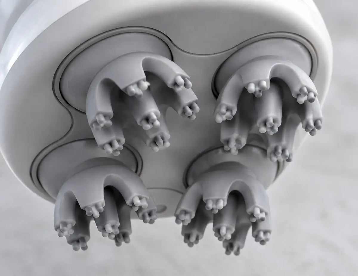 A detailed underside macro of the exact Nuage scalp massager from the reference, filling the frame w